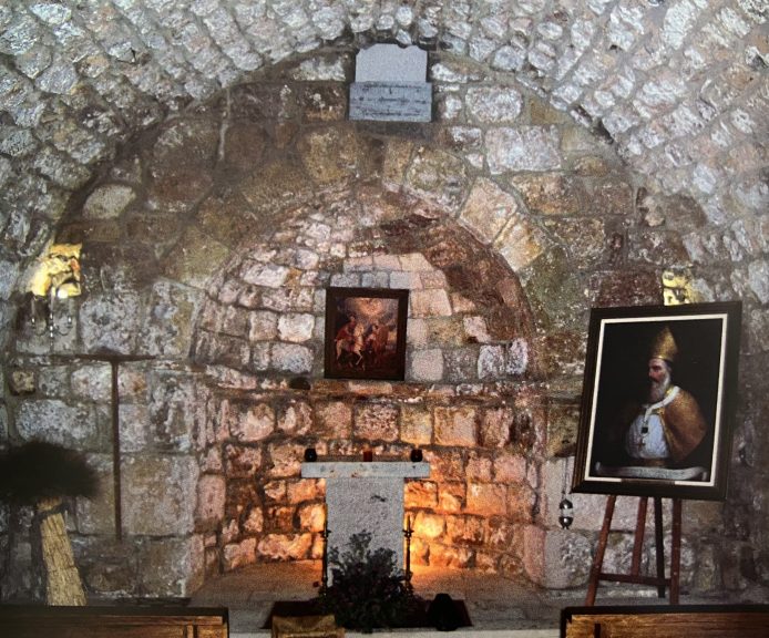 Intérieur voûté en pierre de l’église du VIIIe siècle : autel, icône et portrait d’un patriarche sur chevalet